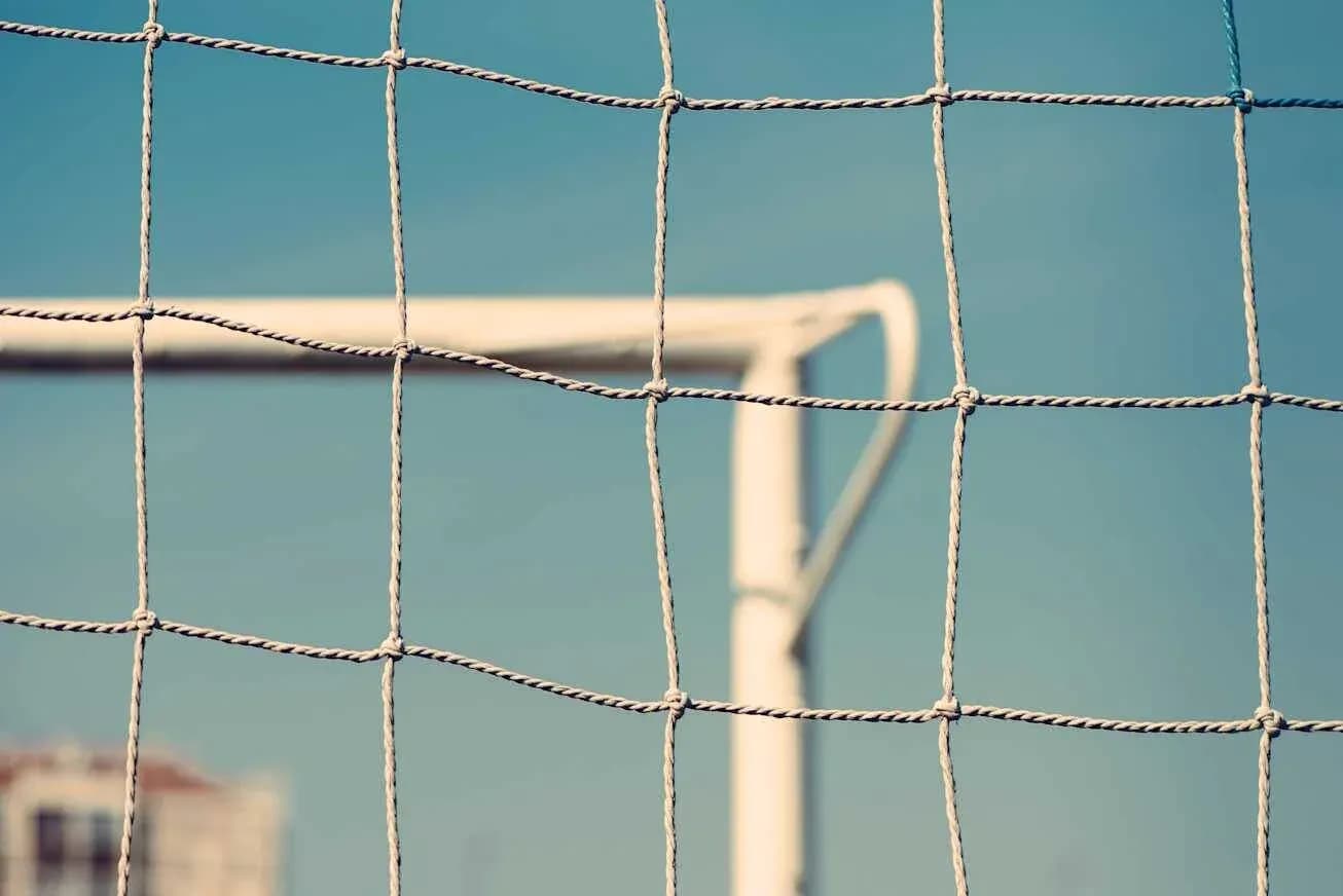 Close-up of soccer goal net against blue sky Close-up of soccer goal net against blue sky