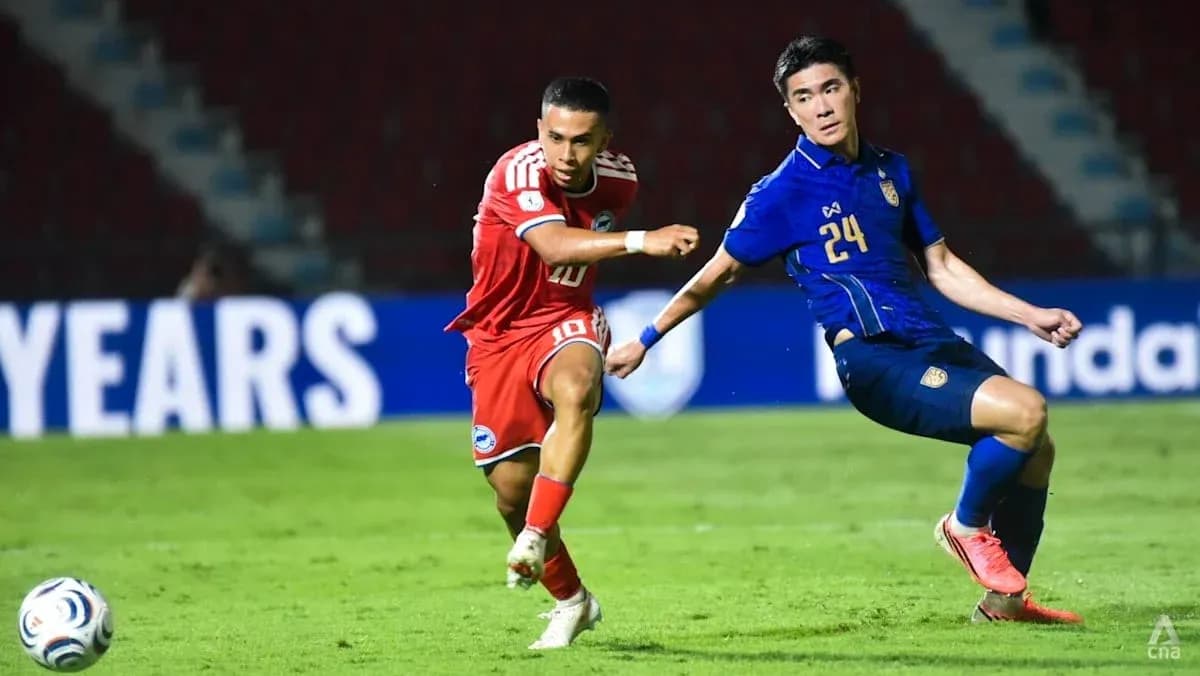 Player in red dribbling past defender in blue jersey Player in red dribbling past defender in blue jersey