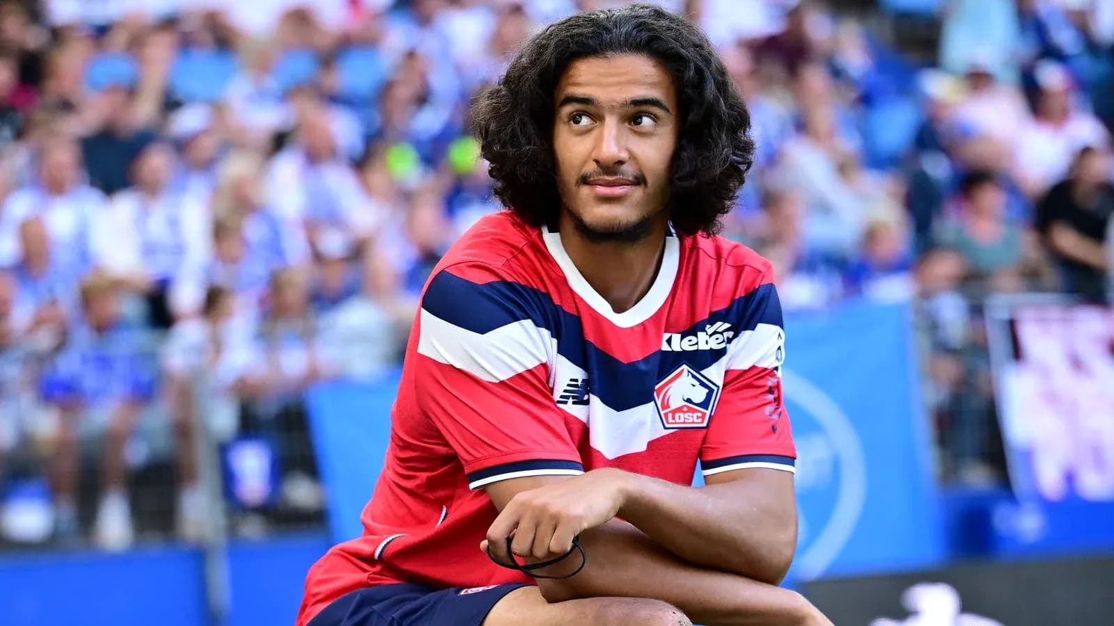 Player in Lille OSC kit sitting on pitch Player in Lille OSC kit sitting on pitch