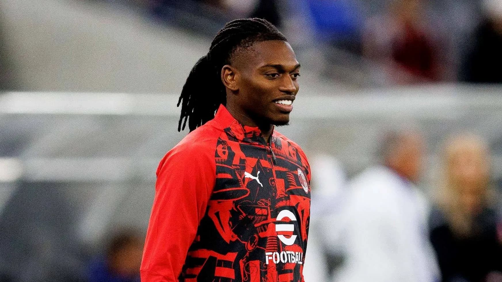 Player in red training kit smiling on the field Player in red training kit smiling on the field
