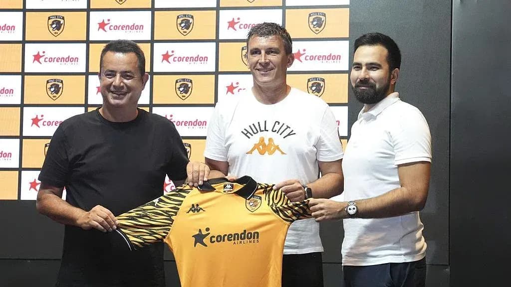 Manager holding Hull City jersey at press event Manager holding Hull City jersey at press event