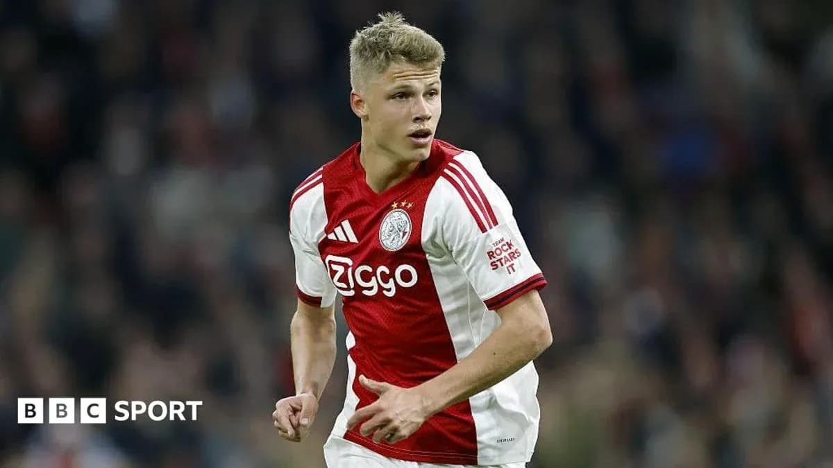 Player in Ajax kit running on the pitch Player in Ajax kit running on the pitch