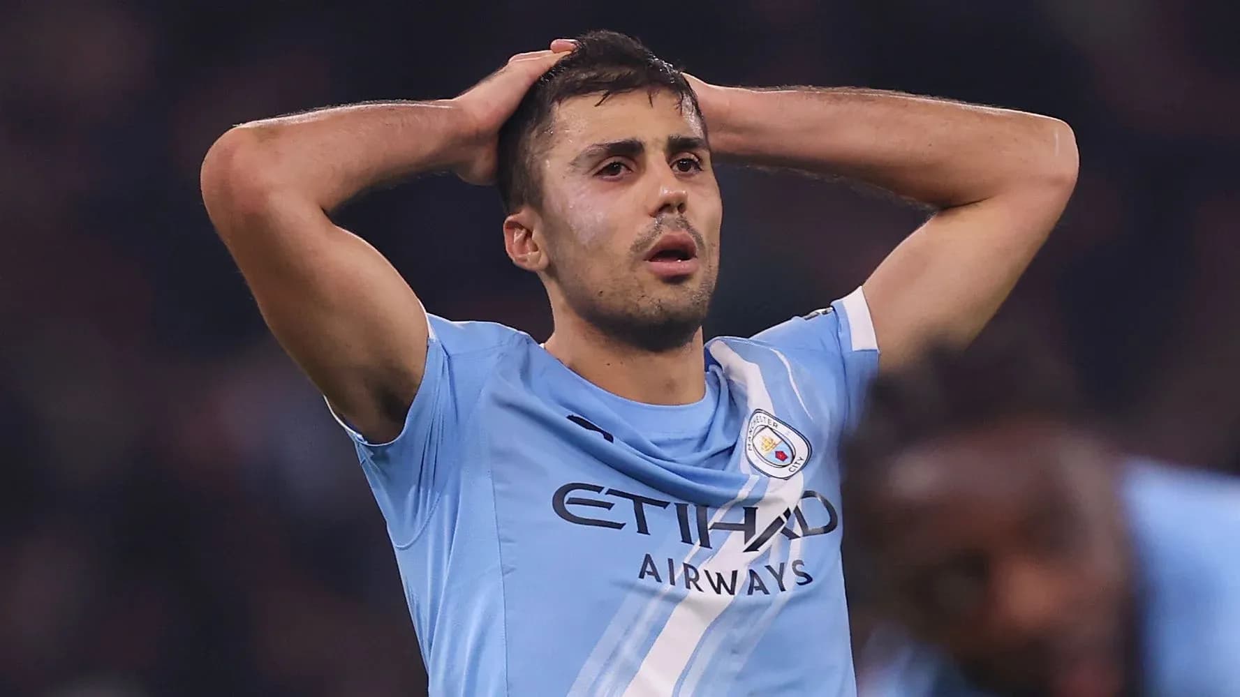 Player in Manchester City jersey holding head in frustration Player in Manchester City jersey holding head in frustration