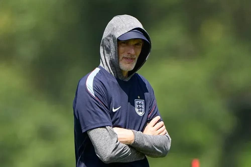Coach in hoodie observing training session outdoors Coach in hoodie observing training session outdoors