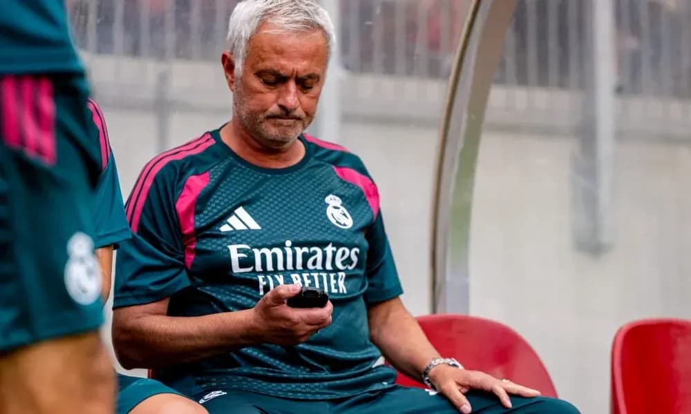 Coach sitting on bench checking phone during match Coach sitting on bench checking phone during match