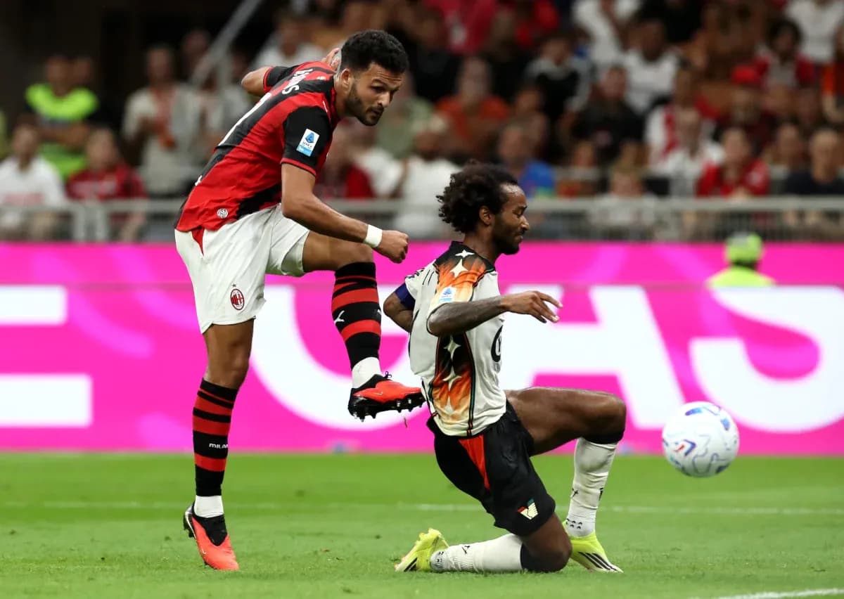 AC Milan player challenges Venezia opponent during match AC Milan player challenges Venezia opponent during match