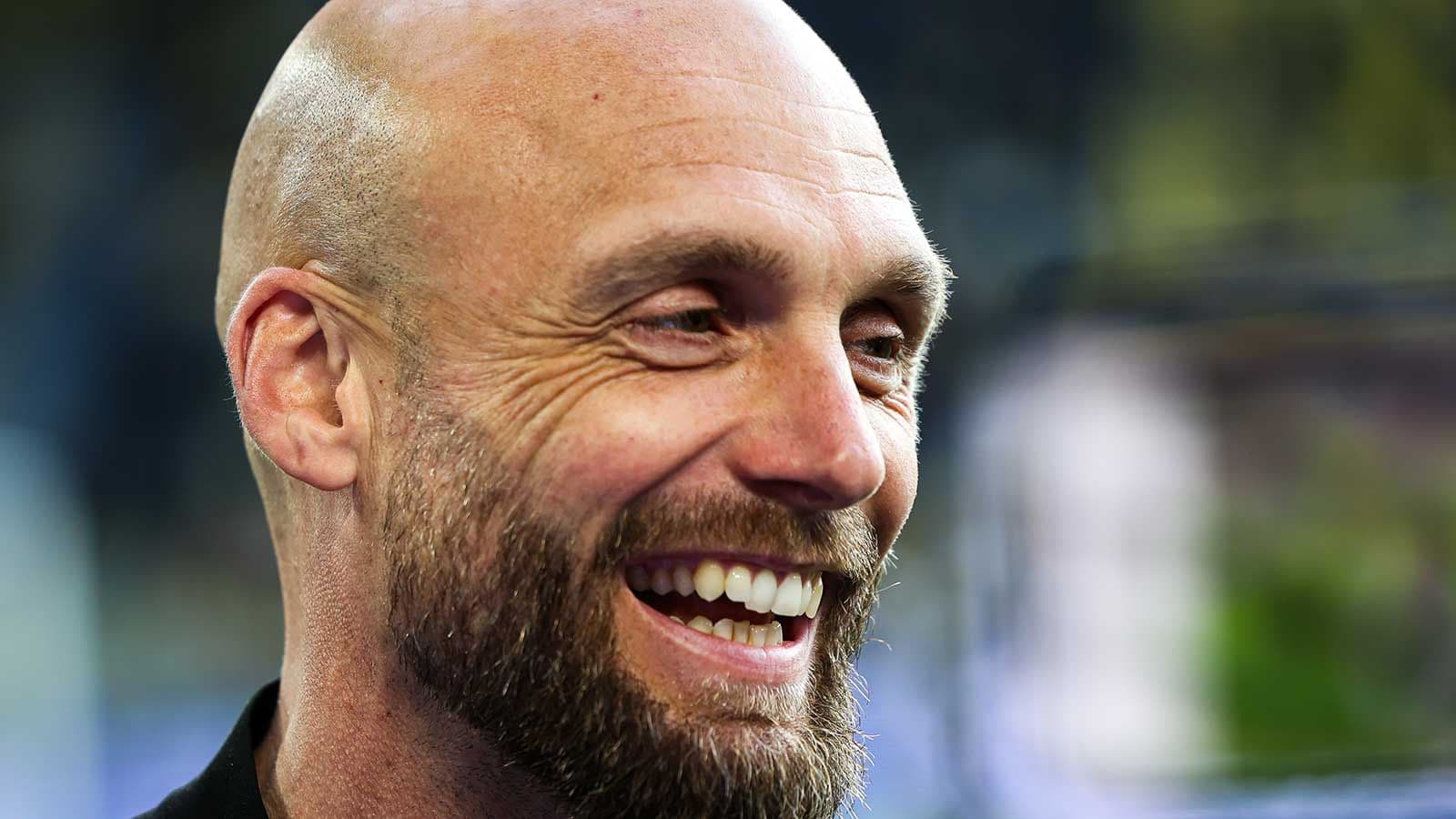 Smiling man with a beard during an event Smiling man with a beard during an event