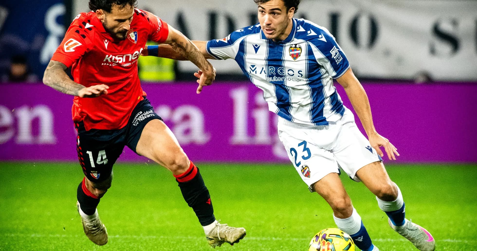 Levante player dribbling against Osasuna opponent Levante player dribbling against Osasuna opponent