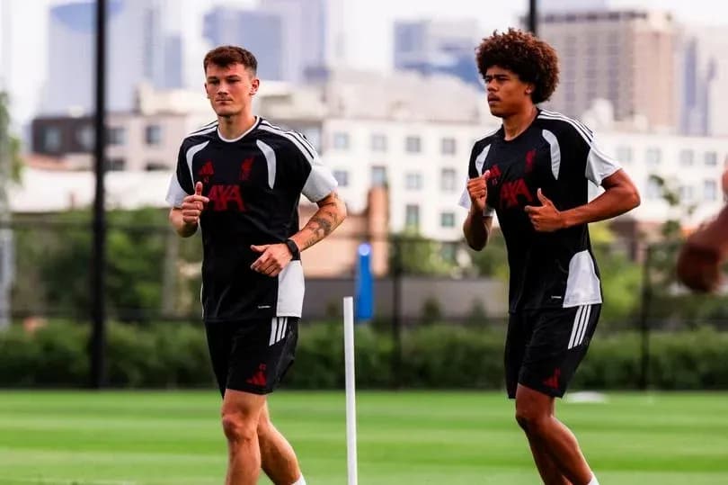Two players jogging during training session on pitch Two players jogging during training session on pitch