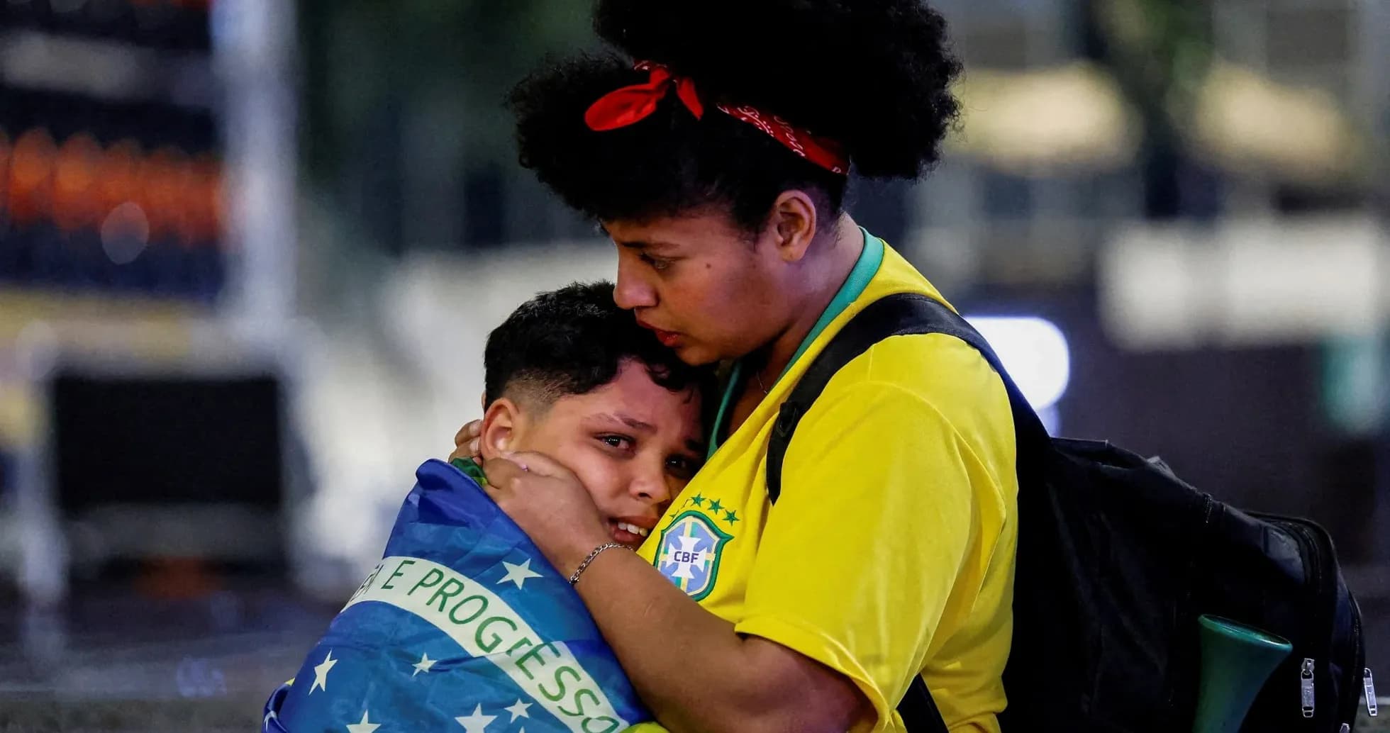 Mother comforting child wrapped in Brazilian flag Mother comforting child wrapped in Brazilian flag