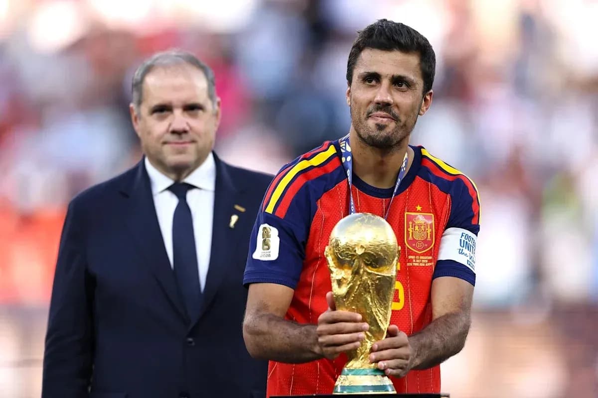 Player holding World Cup trophy with official present Player holding World Cup trophy with official present